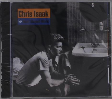 Text: "Chris Isaak, Heart Shaped World." Schwarz-weiß Foto eines Mannes neben einem Waschbecken in einem Badezimmer.