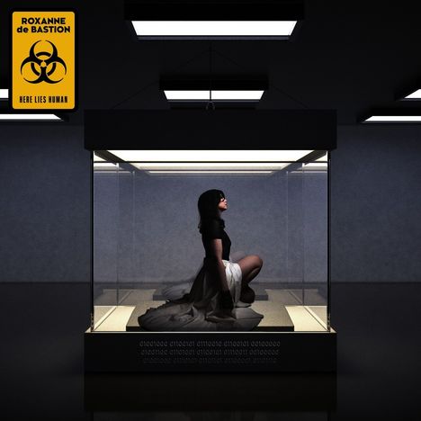 Text: "ROXANNE de BASTION HERE LIES HUMAN". Eine Person kniet in einem Glaskasten unter hellen Deckenleuchten.
