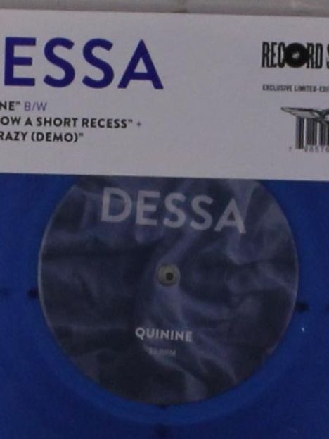 "DESSA" und "QUININE" stehen auf einer blauen Schallplatte. Oben sind weitere Songtitel angegeben.