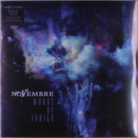 Text: "NOVEMBRE WORDS OF INDIGO". 
Ein abstraktes, dunkelblaues Gemälde zeigt ein Gesicht in Wolken gehüllt.