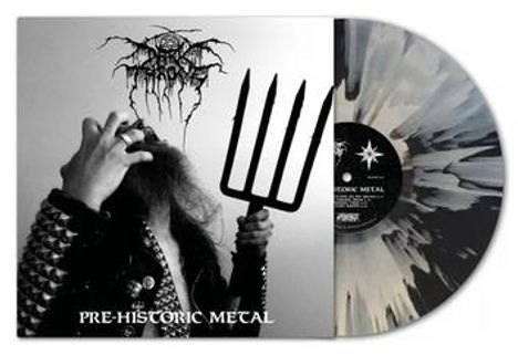 "PRE-HISTORIC METAL" steht unten. Ein Mann mit Nietenjacke hält eine große Forke, dazu eine Schallplatte in Schwarz-Weiß.