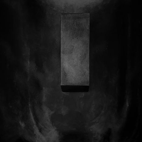 Schwarzes, rechteckiges Objekt vor dunklem Hintergrund. Keine Texte sichtbar, minimalistisches Design.