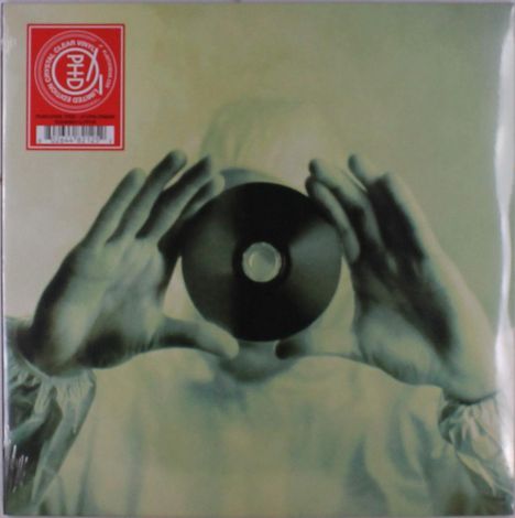 Ein roter Aufkleber zeigt den Text: "Limited Edition: Colored, Clear Vinyl". Hände halten eine CD vor einem Gesicht.