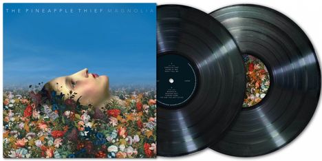 Text: "THE PINEAPPLE THIEF MAGNOLIA". Das Cover zeigt ein Gesicht in einem Blumenfeld, daneben zwei schwarze Schallplatten.