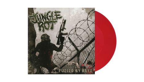 „JUNGLE ROT“ und „FUELED BY HATE“. Eine düstere Illustration mit einer Figur in Gasmaske, Gewehr und Stacheldraht.