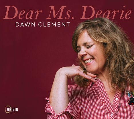 Text: "Dear Ms. Dearie" und "Dawn Clement". Frau in rot-weiß kariertem Hemd, lächelt mit geschlossenen Augen, roter Hintergrund.