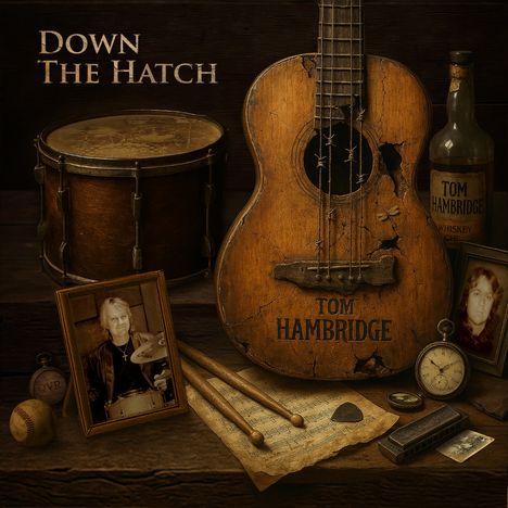 "Down the Hatch", "Tom Hambridge" auf einer abgenutzten Gitarre. Trommel, Whiskyflasche, Fotos, Noten, Mundharmonika.