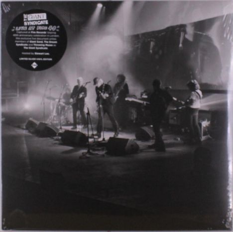 Text: "THE GIANT SYNDICATE 'LIVE IN EURO 40'". Schwarz-weißes Foto einer Band auf einer Bühne mit Lichtstrahlen.