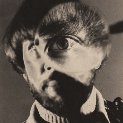 Keine erkennbaren Texte. Ein Porträt, das durch Verzerrung surreal wirkt: Ein Gesicht mit übergroßem Auge.