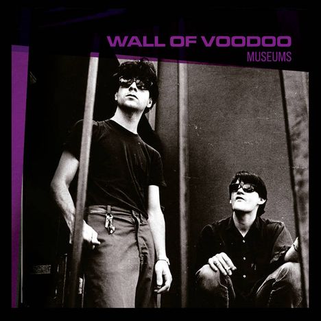 "WALL OF VOODOO, MUSEUMS" in lila Schrift oben. Zwei Männer mit Sonnenbrillen in einem schwarz-weißen Foto, einer stehend, einer hockend.