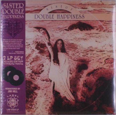 "SISTER DOUBLE HAPPINESS" steht oben. Eine Frau steht mit erhobenem Arm vor einer stürmischen Küste.