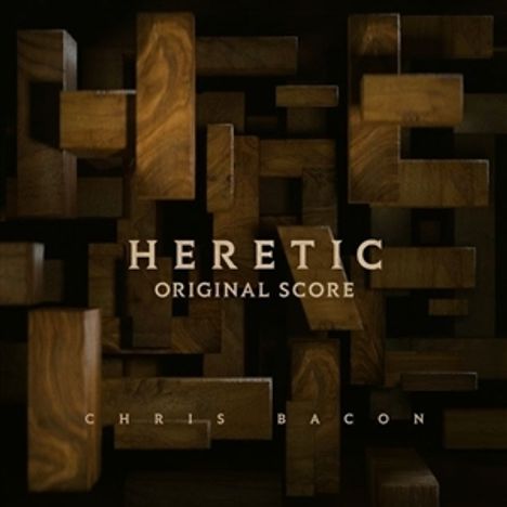 "HERETIC ORIGINAL SCORE" und "CHRIS BACON" auf dunklem Hintergrund aus ineinander verschachtelten Holzteilen.
