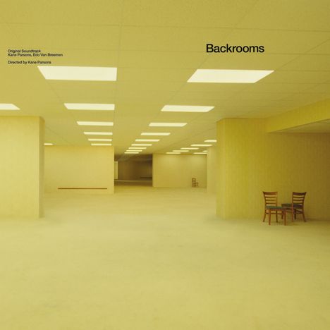 "Backrooms", Soundtrack von Kane Parsons und Edo Van Breemen. Ein leerer, gelber Raum mit Tischen und Stühlen.
