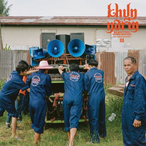 Text: "Khun Narin Electric Phin Band." Fünf Menschen in blauen Overalls schieben eine mit Lautsprechern beladene Anlage.