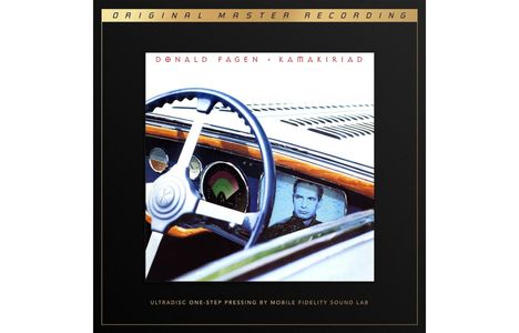 "Donald Fagen Kamakiriad" auf einem schwarzen Rand. Innerhalb ein Autoinnenraum mit Lenkrad und Bildschirm, der ein Gesicht zeigt.