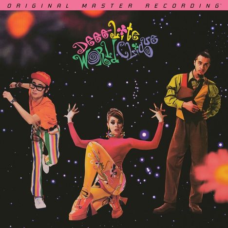 Text: "Deee-Lite World Clique". Drei Personen in lebhafter Kleidung vor einem Hintergrund mit leuchtenden Punkten.