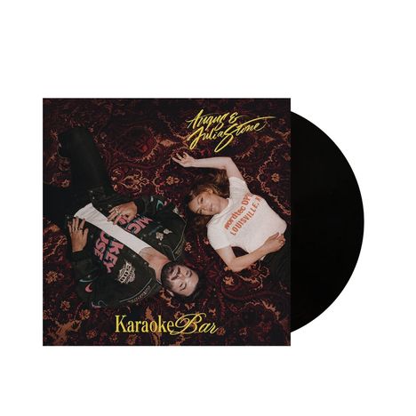 Text: "Angus & Julia Stone", "Karaoke Bar", "Derby City Louisville". Zwei Personen liegen auf einem gemusterten Teppich.