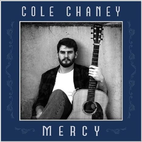 Text: "COLE CHANEY" oben, "MERCY" unten. Ein Mann lehnt sitzend mit einer Gitarre an einer Wand. Rahmen in Blau mit Verzierungen.
