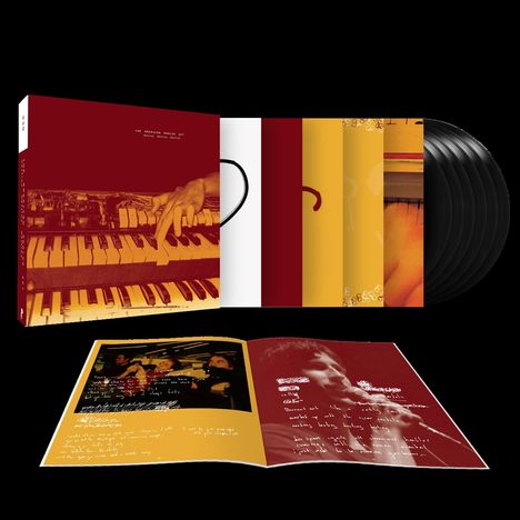 Musikalbum-Set mit mehreren Plattenhüllen. Ein geöffneter Prospekt zeigt handgeschriebene Texte und Fotos von einer Band.