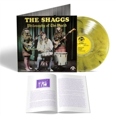Auf einer Vinylhülle steht "THE SHAGGS Philosophy of the World". Eine gelbe Schallplatte und ein offenes Buch sind ebenfalls sichtbar.