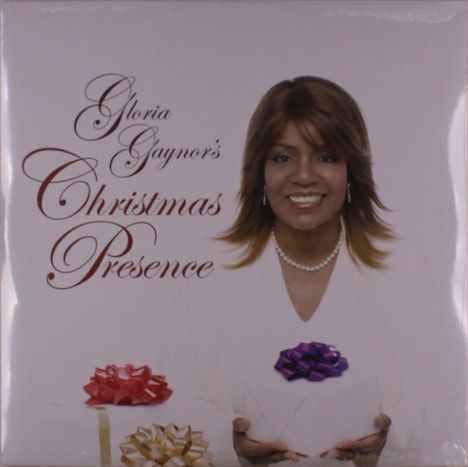 "Gloria Gaynor's Christmas Presence" in eleganter Schrift. Eine lächelnde Frau hält Geschenke mit roten, lilafarbenen und goldenen Schleifen.