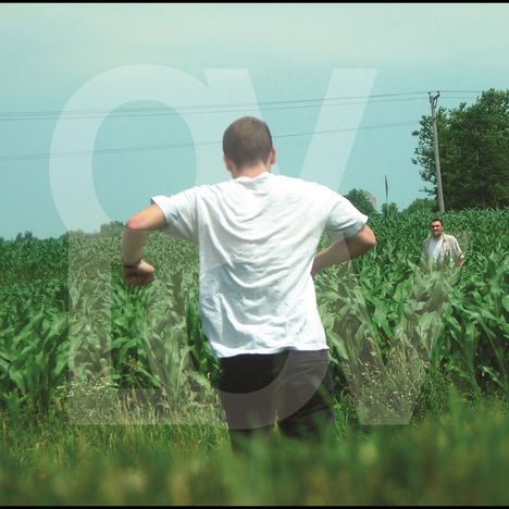 Großes, halbtransparentes "OV". Zwei Männer im Feld, der vordere im weißen T-Shirt läuft, der hintere schaut.