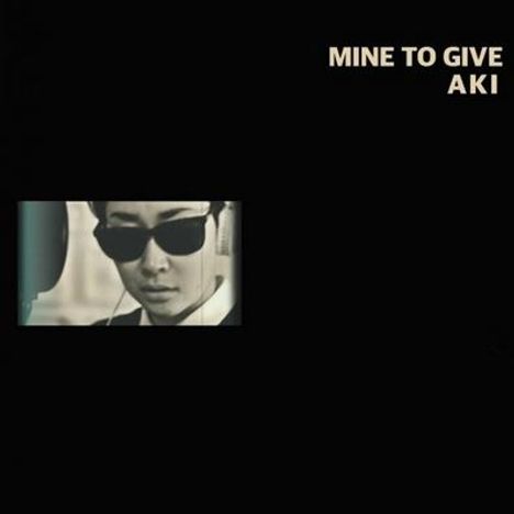 Text: "MINE TO GIVE AKI". Schwarz-weißes Foto einer Person mit Sonnenbrille und Kopfhörern.