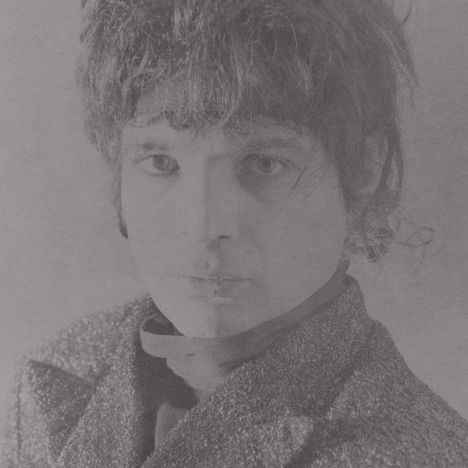 Es gibt keinen Text zu beachten. Schwarz-weiß Fotografie einer Person mit lockigem Haar und ernstem Gesichtsausdruck.