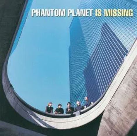 "PHANTOM PLANET IS MISSING" in Großbuchstaben. Fünf Menschen sitzen auf einer Betonstruktur, Wolkenkratzer im Hintergrund.