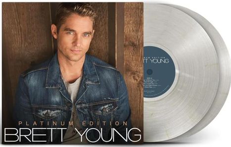 Platinum Edition Brett Young. Ein Mann in Jeansjacke lehnt an einer Holzoberfläche, daneben zwei transparente Schallplatten.