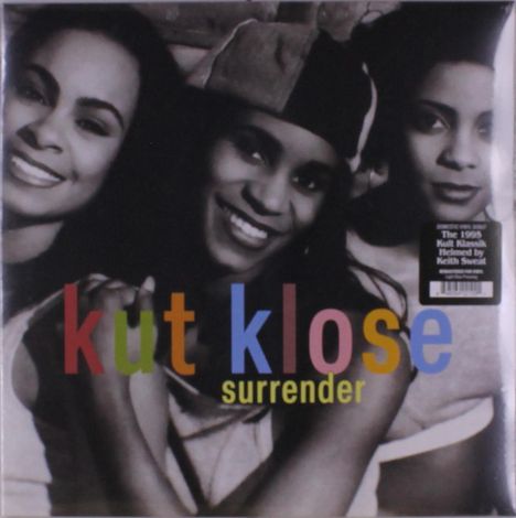 „kut klose, surrender“. Drei lächelnde Frauen in Nahaufnahme. Schwarz-weiß mit farbigem Text.