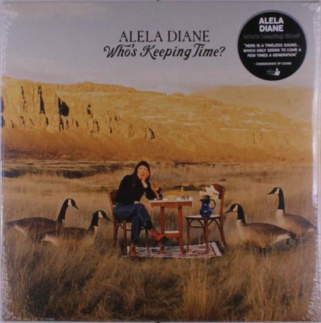 "ALELA DIANE Who's Keeping Time?" Frau sitzt im Freien an einem Tisch, umgeben von Gänsen, mit Felsen im Hintergrund.