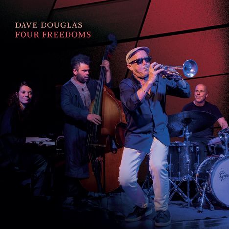 “DAVE DOUGLAS FOUR FREEDOMS”. Eine Jazzband spielt mit Trompete, Kontrabass, Schlagzeug und Klavier in einer stimmungsvollen Beleuchtung.