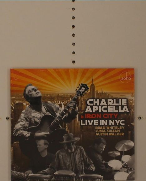 Cover mit Text: "Charlie Apicella & Iron City Live in NYC". Zu sehen sind Musiker und die Skyline von New York.