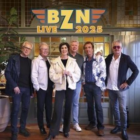 "BZN Live 2025" steht oben. Sechs Personen in stilvoller Kleidung posieren vor einer dekorativen Wand.