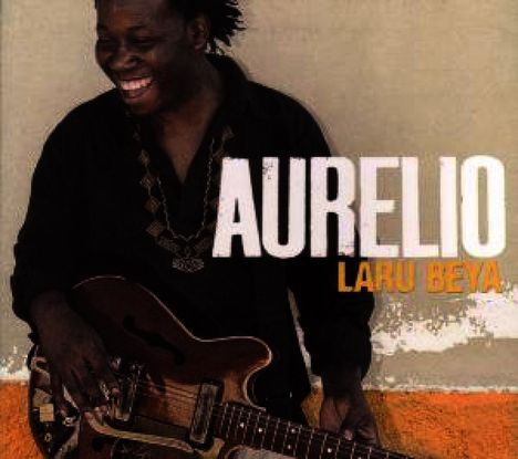 Text: Aurelio, Laru Beya. Ein Mann lacht, hält eine Gitarre, Hintergrund in Beige und Orange.