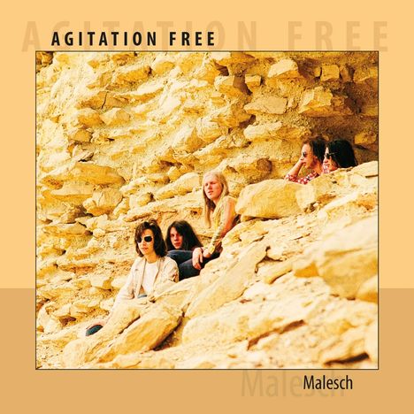 „AGITATION FREE“, „Malesch“; Vier Personen sitzen in grober natürlicher Steinlandschaft.