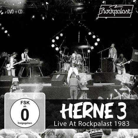 HERNE 3 Live At Rockpalast 1983. FSK ab 0 freigegeben. Schwarze Bühne, Band spielt, Publikum im Vordergrund, Kameras filmen.