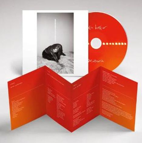 CD und Booklet. CD: "ki&mi", "materia". Schwarz-Weiß-Foto von Person. Orange-Rotes Booklet mit Texten.