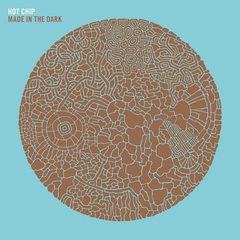 Text: "HOT CHIP MADE IN THE DARK". Illustration eines braunen, labyrinthartigen Kreises auf hellblauem Hintergrund.