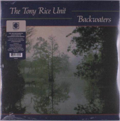 „The Tony Rice Unit Backwaters“. Naturfoto mit nebligem Fluss, gesäumt von Bäumen im Hintergrund.