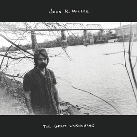 "John R. Miller, The Great Unknowing". Ein Schwarz-Weiß-Foto zeigt eine Person am Fluss, Hintergrund Brücke.