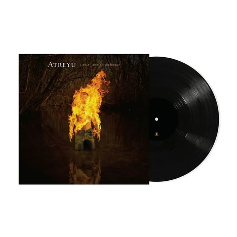 „ATREYU - A Death-Grip On Yesterday“. Eine brennende Person steht knietief im Wasser. Vinyl-Schallplatte rechts.
