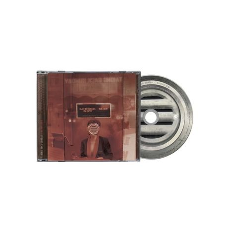 "Louder Now" ist der Haupttext. Ein Mann in Anzug mit rundem Mikrofon über dem Gesicht, daneben eine CD mit Schlitzen.