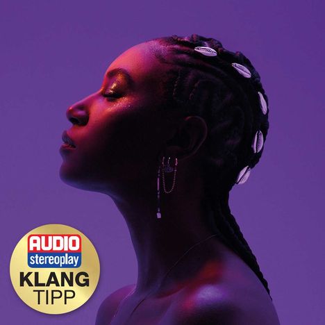 Text: "AUDIO stereoplay KLANG TIPP." Eine Person im Profil, mit Schmuck und Zöpfen, auf violettem Hintergrund.