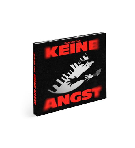 Der Text „KEINE ANGST“ erscheint groß in Rot. Er zeigt einen Menschen, der vor einem riesigen, weißen Klavier flieht.