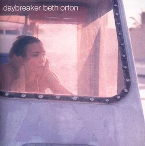 Text: "daybreaker beth orton". Eine Person schaut durch ein Fenster mit einer ruhigen, nachdenklichen Ausstrahlung.