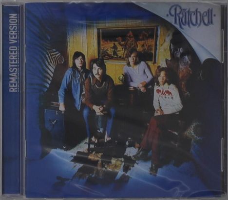 "Remastered Version" und "Ratchell" sind erwähnt. Eine Gruppe von vier Personen sitzt in einem Raum vor einem bunten Gemälde.