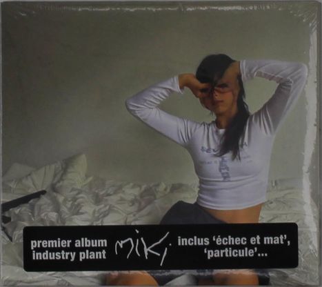 „Premier album industry plant“, „miki“, „inclus ‘échec et mat’, ‘particule’“. Frau sitzt mit erhobenen Armen auf einem Bett.