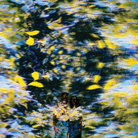 Verschwommene gelbe und blaue Farben dominieren, mit zwei Personen im unteren Bereich, die von den Farben überlagert sind.